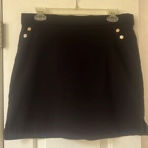 Black skirt, elastic waist with front pockets and shorts built in, size 8